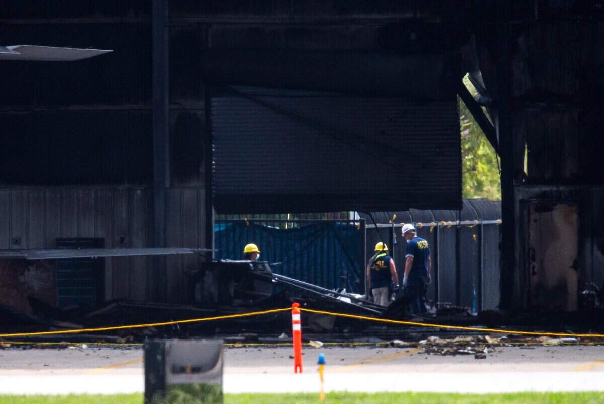 National Transportation Safety Board and FBI investigators on Monday inspect an airport hangar in Addison, the day after a twin-engine plane crashed into the building, killing all 10 people on board.