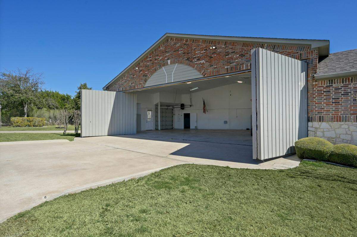 The house is nestled within Lakeway (Texas) Airpark and backs up to The Hills Country Club.