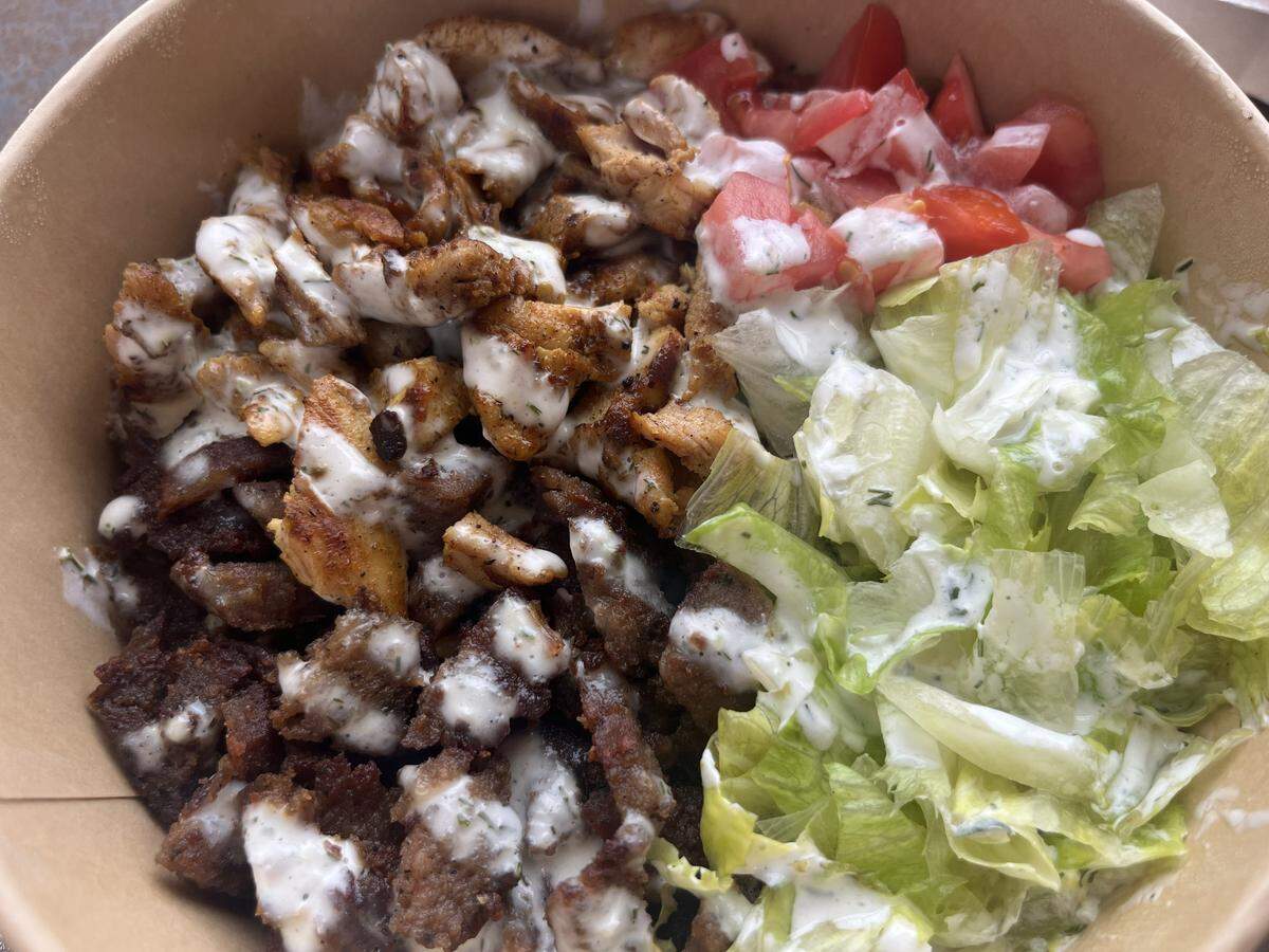 The mixed bowl from the Rolling Gyro has chicken and gyro beef with rice, lettuce, tomato and their white sauce.