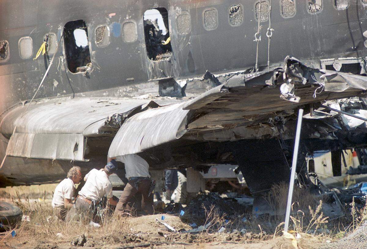 Aug. 31, 1988: Three investigators examine a portion of the destroyed wing of Delta Flight 1141, a Boeing 727 that crashed that morning during takeoff at Dallas-Fort Worth International Airport.