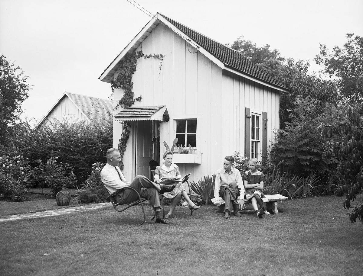 July 13, 1940: The W. C. (Mann) Lucas family, at Grapevine, Texas, is shown relaxing in lawn furniture outside Mrs. Lucas’ studio, converted from a 40-year-old smokehouse. Pictured are Mr. and Mrs. Lucas and their son and daughter.