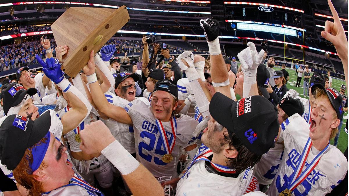 Gunter running back Marshall Magers holds the championship trophy as the Tigers celebrate winning the UIL Conference 3A Division 2 state championship football game at AT&T Stadium in Arlington, Texas, Thursday, Dec. 14, 2023.