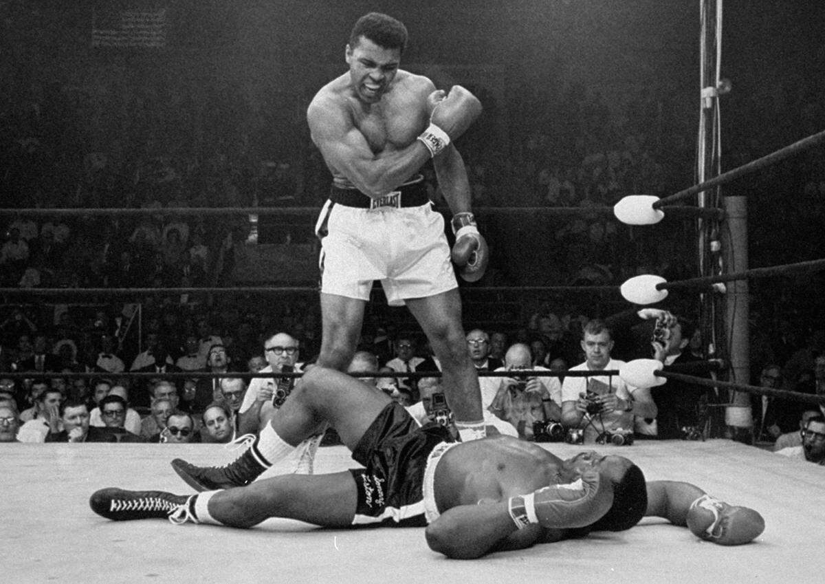 FILE - In this May 25, 1965, file photo, heavyweight champion Muhammad Ali stands over fallen challenger Sonny Liston shortly after dropping him with a short hard right to the jaw in Lewiston, Maine. Ali’s Kentucky hometown will honor the late boxer by renaming its airport for him. The Louisville Regional Airport Authority’s board voted Wednesday, Jan. 16, 2019, to change the name to Louisville Muhammad Ali International Airport. Ali would have turned 77 Thursday. He died in 2016. (AP Photo/John Rooney, File)