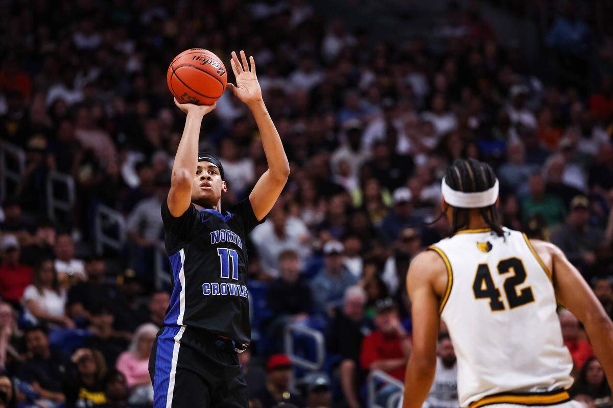 North Crowley forward Trey Hall (11) attempts a three pointer over a San Antonio Brennan defender in the Class 6A Division I state championship at The Alamodome in San Antonio, Texas, March 14, 2026.