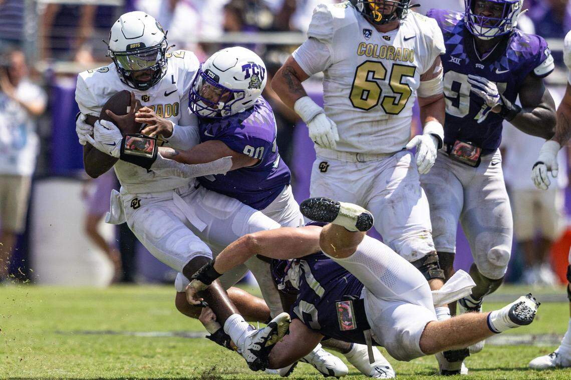 Colorado quarterback Shedeur Sanders (2) is sacked by TCU defenders Shad Banks Jr. and Caleb Fox (90) in the fourth quarter of a college football game between the TCU Horned Frogs and the Colorado Buffaloes at Amon G. Carter Stadium in Fort Worth on Saturday, Sept. 2, 2023.