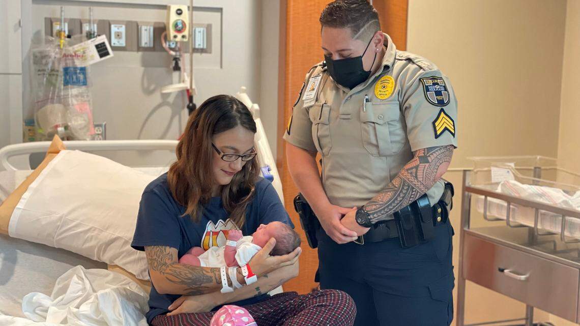 Morgan Lee, left, baby Charlie and officer Sandra Cartagena pose for a photo.