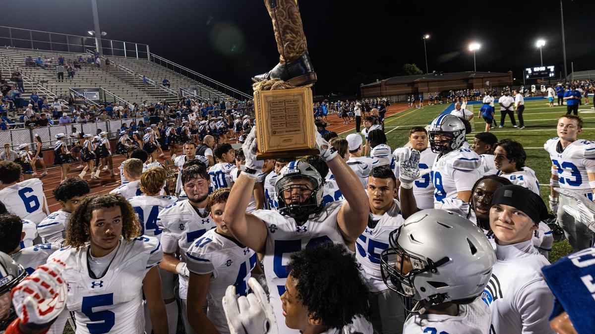 The Burleson Centennial Spartans football team hoists the Boot Bowl trophy after winning the 2024 Boot Bowl game against Burleson High School at BISD Stadium in Burleson on Friday, Aug. 30, 2024. The Spartans defeated the Elk 28-7 to take home the Boot Bowl trophy for the third year in a row.