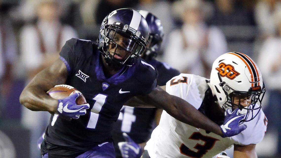 TCU wide receiver Jalen Reagor (1) gives Oklahoma State linebacker Kenneth Edison-McGruder (3) a stiff-arm after making a catch during the first quarter of an NCAA college football game in Fort Worth, Texas, Saturday, Nov. 24, 2018.