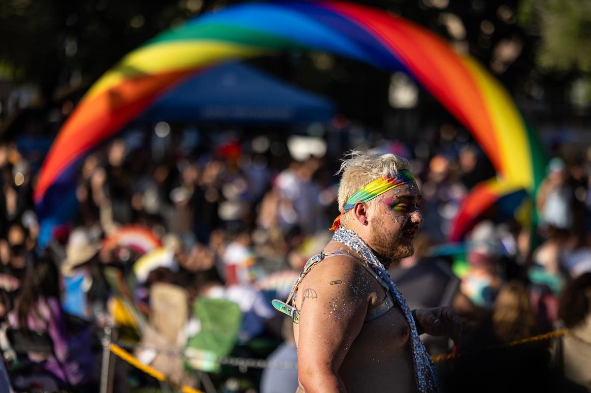 Xander Pitts walks back to his set up near the stage to view the performances for the Arlington Pride event at Levitt Pavilion in Arlington on Saturday, June 8, 2024.