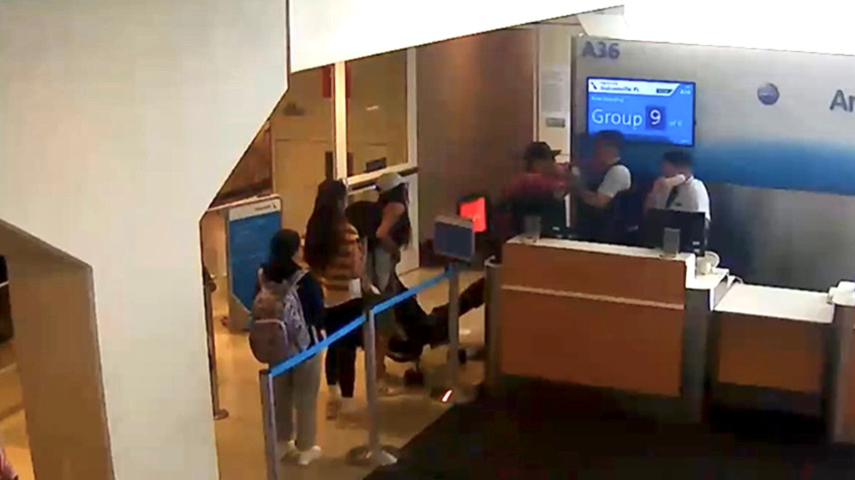 A frame from security footage at DFW Airport shows 53-year-old Keith Charles Owens repeatedly punching an American Airlines gate agent.