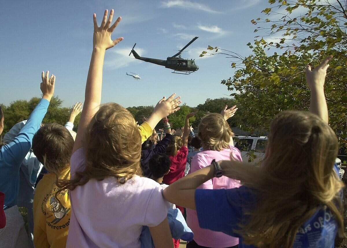 Nov. 11, 2003: Students at Grapevine Elementary wave farewell to a restored Bell UH-1 “Huey” that made a stop on Veterans Day morning. Gen. Dick Stephenson and others spoke to third- to fifth-graders, many of whom had seen the aircraft a year ago, when it came through on tour. The Huey, which served in Vietnam and was shot down a reported three times, was restored through the efforts of DynCorp, U.S. Helicopters, AMR and the Allied Pilot’s Association. The aircraft is hangared at the Texas Air Command Museum at Meacham Field.