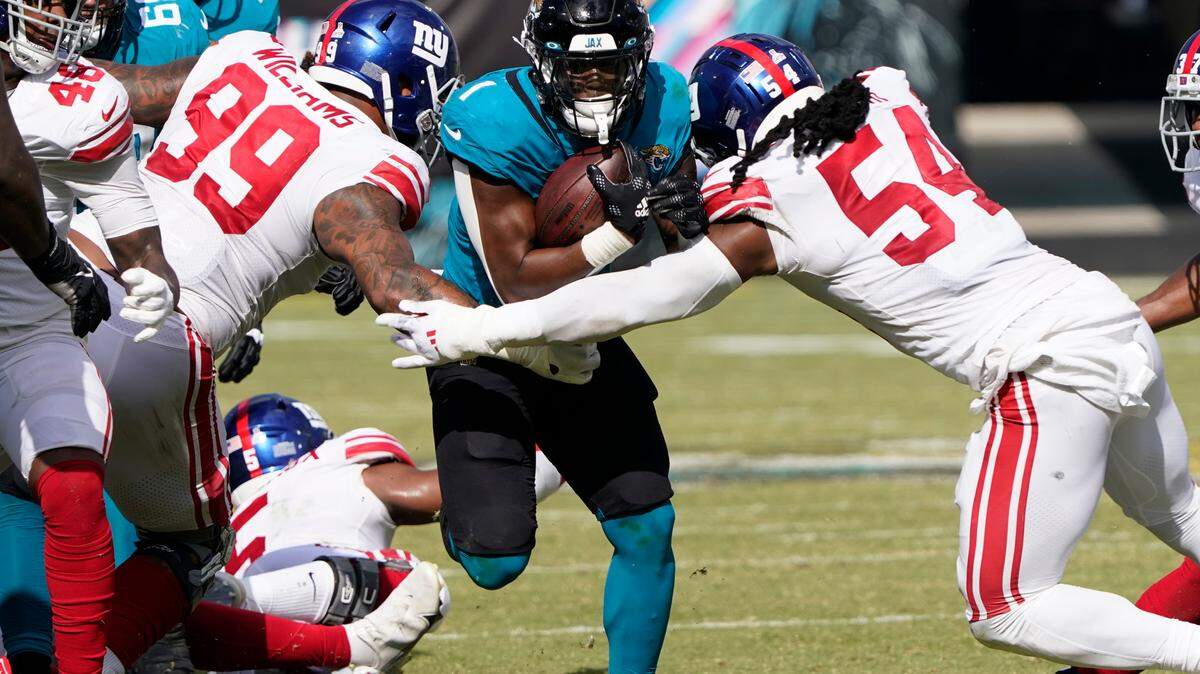 Jacksonville Jaguars running back Travis Etienne Jr. (1) splits between New York Giants defensive end Leonard Williams (99) and linebacker Jaylon Smith (54) Sunday in Jacksonville, Fla.