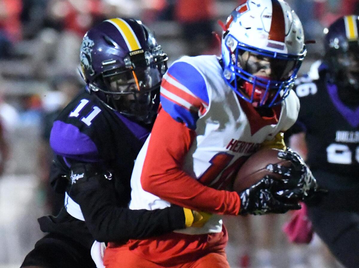 Everman’s Howard Evans-Sauls, left, tries to hold back Midlothian Heritage’s Tae Jackson a he runs 29 yards for a touchdown to take 7-0 lead in the first quarter of Thursday’s November 4, 2022, District 5-5A Division 2 football game at Marr Stadium in Everman, Texas. Special/Bob Haynes