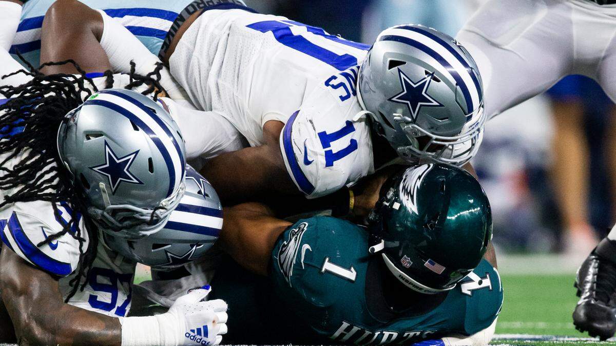 Dallas Cowboys linebacker Micah Parsons (11), middle linebacker Jaylon Smith (9) and defensive tackle Osa Odighizuwa (97) combine to tackle Philadelphia Eagles quarterback Jalen Hurts (1) during an NFL football game in 2021.