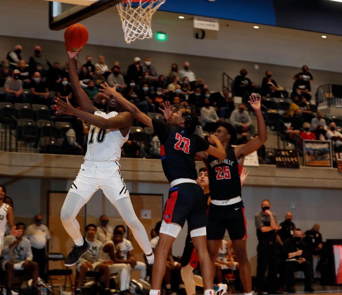 Mansfield forward Andrew Iyamah (10) lays in a left hander against Duncanville forward Cameron Barnes (23) during the second half of a 6A Region 1 quarterfinal basketball game at Arlington ISD Athletics Complex in Arlington, Texas, Saturday, Feb. 27, 2021. Duncanville defeated Mansfield 73-53. (Special to the Star-Telegram Bob Booth)
