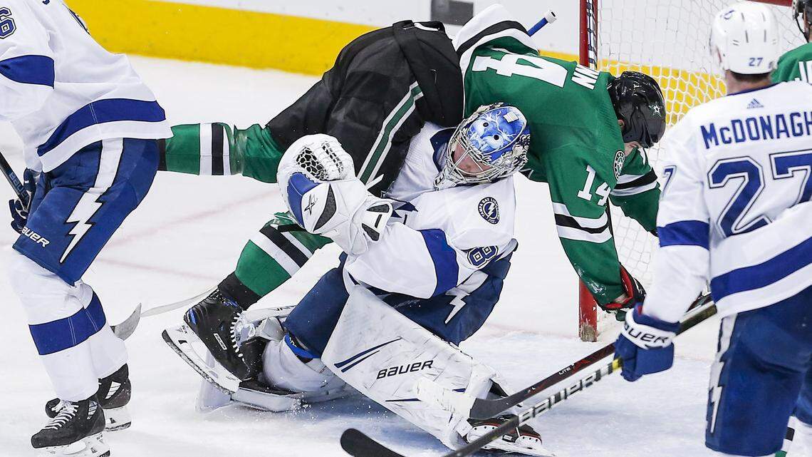 Dallas Stars forward Jamie Benn (14) falls onto Tampa Bay Lightning goaltender Andrei Vasilevskiy (88) during the second period of an NHL hockey game, Tuesday, Jan. 15, 2019, in Dallas. Benn was penalized for goaltender interference on the play. (AP Photo/Brandon Wade)