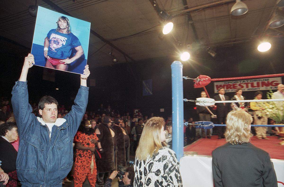 February 19, 1993: A man holds up a portrait of Kerry Von Erich outside of the ring at the Dallas Sportatorium during a memorial for Kerry Von Erich where 3,000 fans gathered to remember the wrestler.
