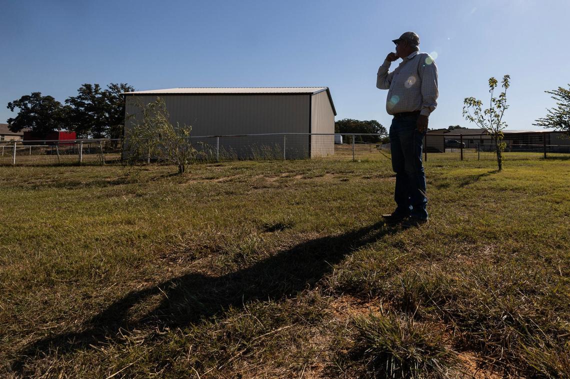 Kendell McGuire inspects his trees that are struggling because of the lack of watering in the backyard of his home in Paradise.