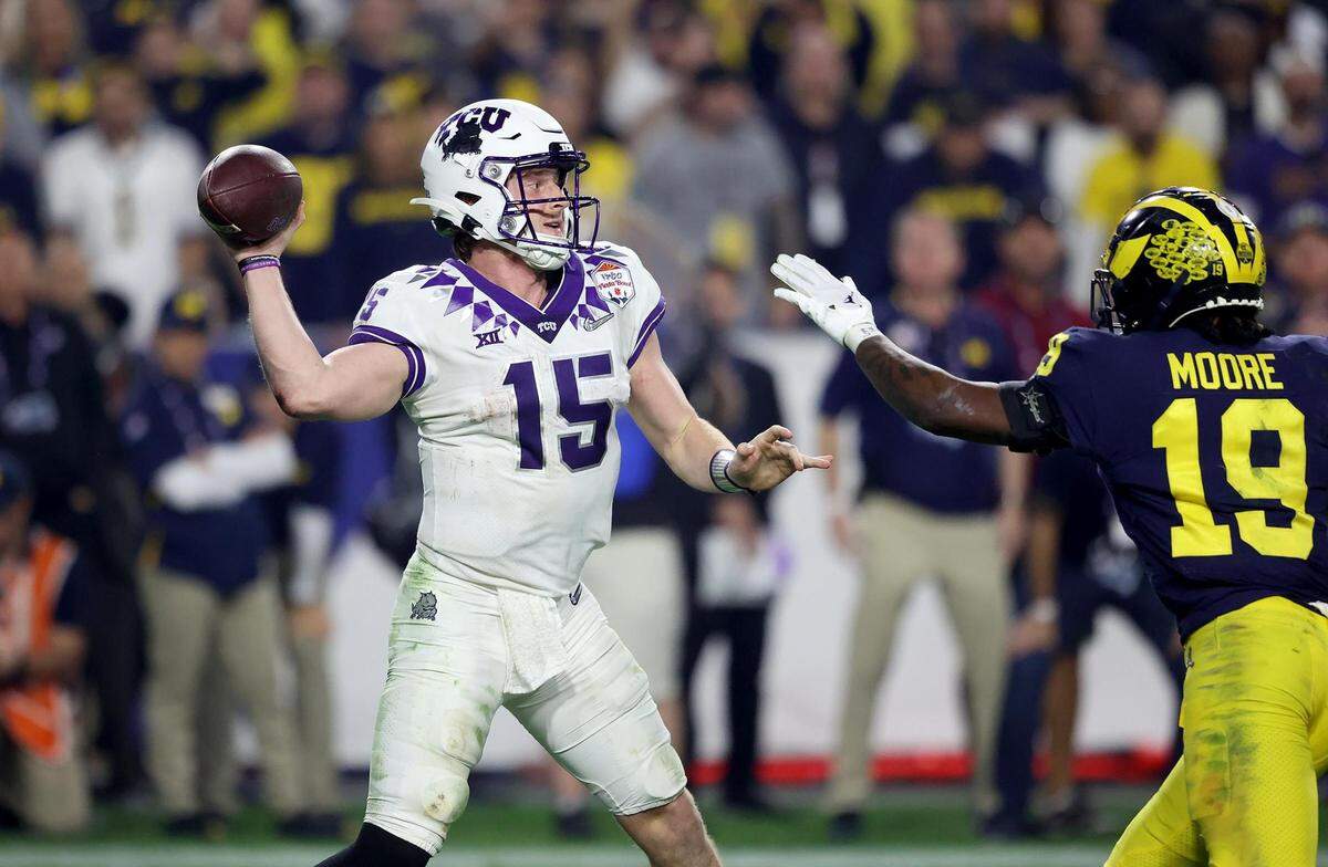 TCU quarterback Max Duggan throws the ball while under pressure from Michigan defensive back Rod Moore at the Vrbo Fiesta Bowl at State Farm Stadium in Glendale, Ariz., on Saturday, December 31, 2022.