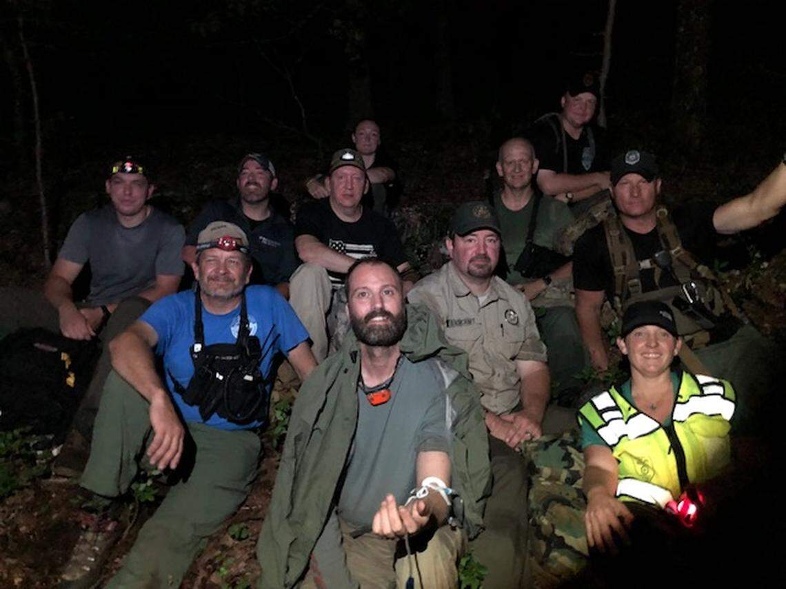 Joshua McClatchy of Fort Worth with rescuers about 10 minutes after they reached the hiker, who was lost in the woods of west Arkansas.