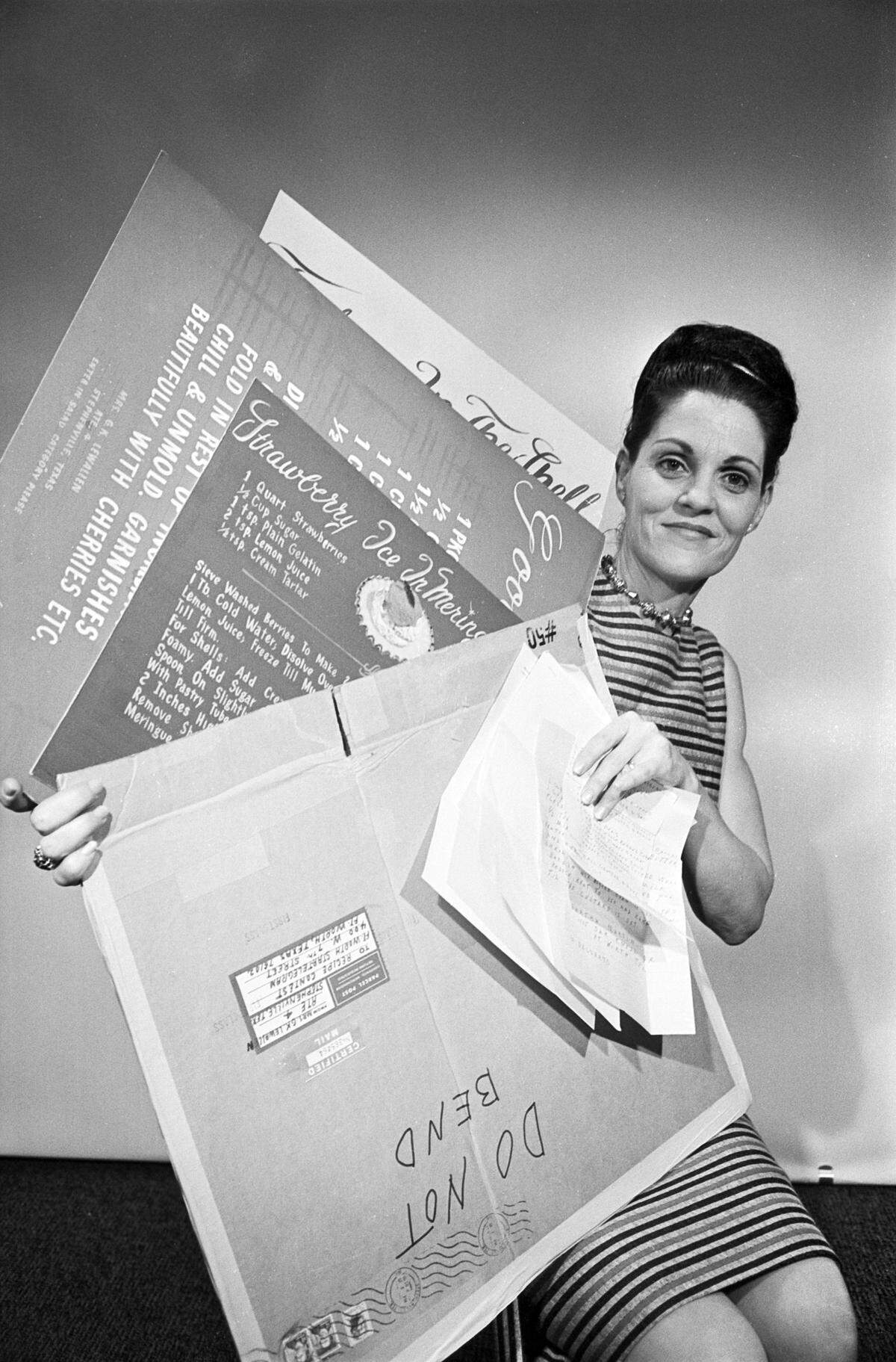 Joyce Pickens, Star-Telegram promotion department receptionist, displays the three most unusual of the entries received in the 1966 Star-Telegram Recipe Contest, all printed on large colored cardboard. 