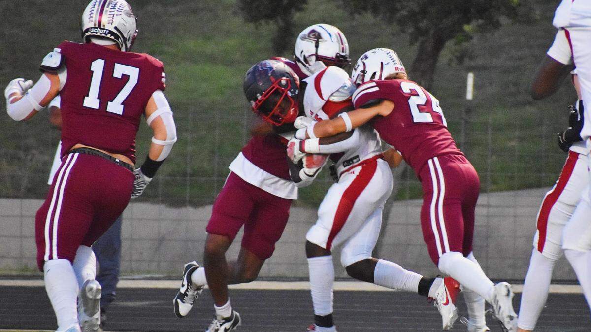 Justin Northwest running back Nate Jean tries to push himself into the end zone while being tackled by a pair of Keller Central defenders, including Luke Hamilton (24) during the first quarter of a UIL football game at KISD Athletic Complex on Thursday, Oct. 10, 2024.