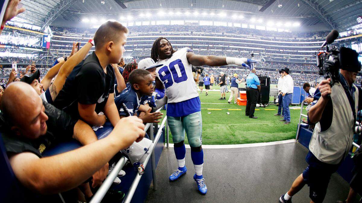 Dallas Cowboys defensive end DeMarcus Lawrence poses for a photo with fans in after beating the Detroit Lions last week. Lawrence will compete on the same stage NFL defensive stars J.J. Watt and Jadeveon Clowney Sunday night in Houston.