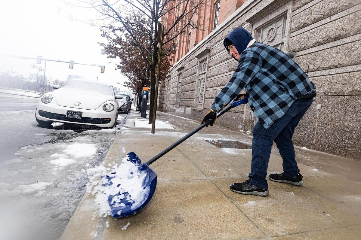 Tarrant County employee Jacob Hernandez shoves snow off the sidewalk in front of the Tarrant County Sheriffs Department Jail in downtown Fort Worth on Thursday, Jan. 9, 2025.