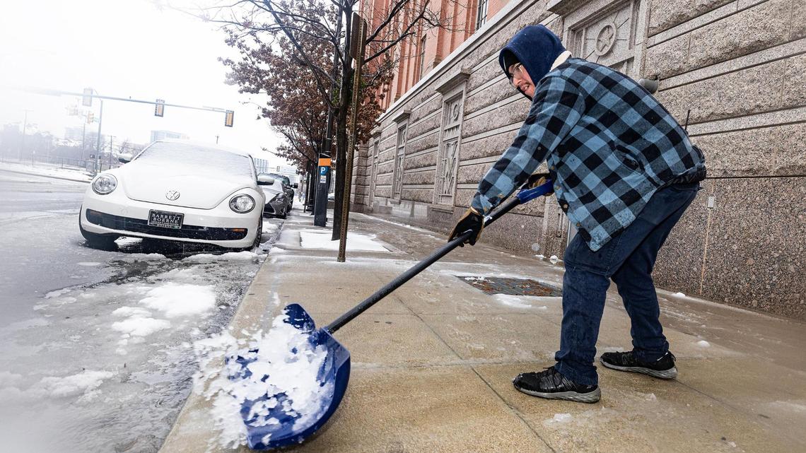Tarrant County employee Jacob Hernandez shoves snow off the sidewalk in front of the Tarrant County Sheriffs Department Jail in downtown Fort Worth on Thursday, Jan. 9, 2025.
