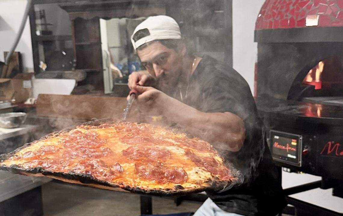 Co-owner Alessandro Salvatore serves a pizza salame piccante, similar to pepperoni, at Felina in Fort Worth, Texas.