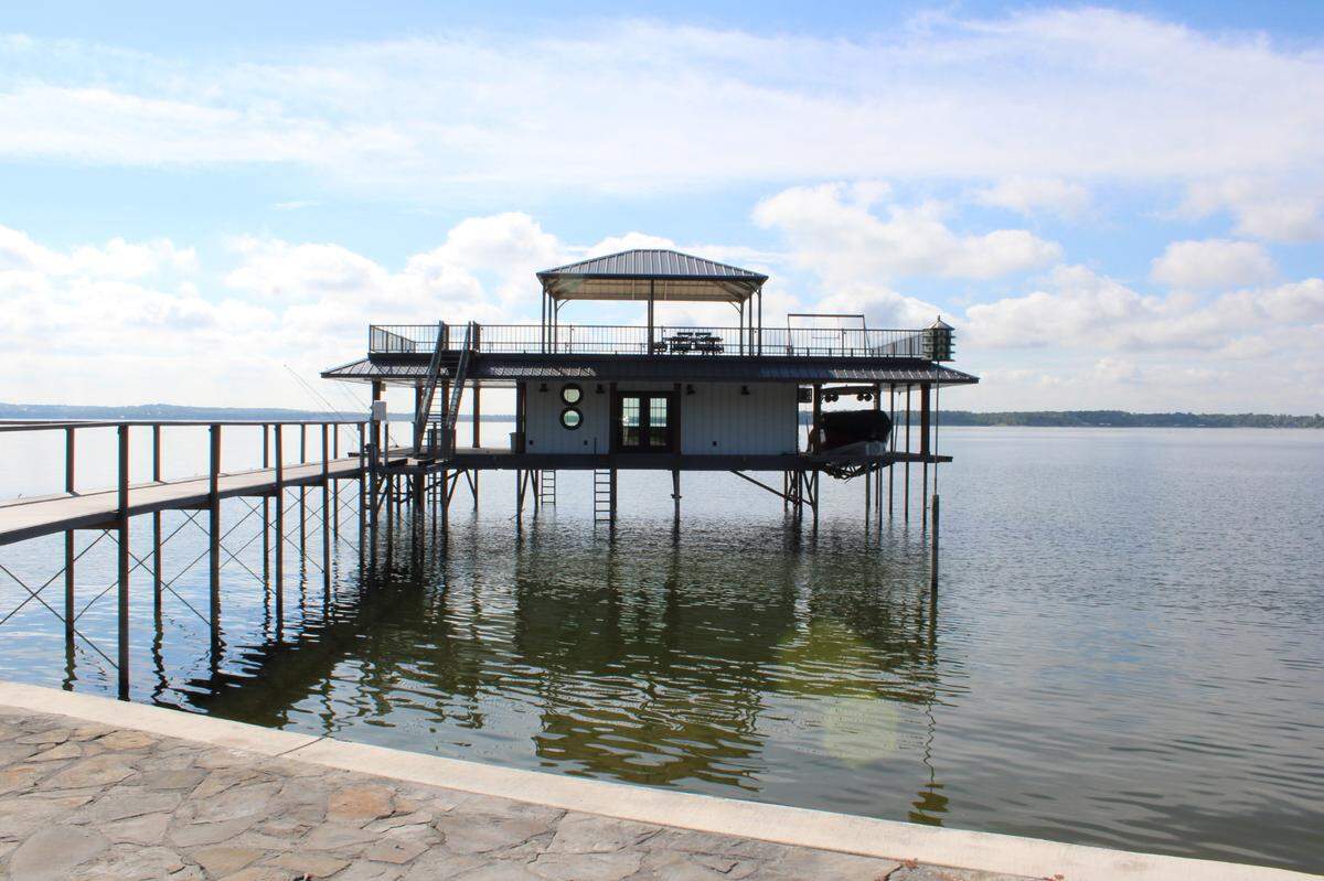 This two story boat dock has an enclosed portion with a full kitchen and rooftop patio.