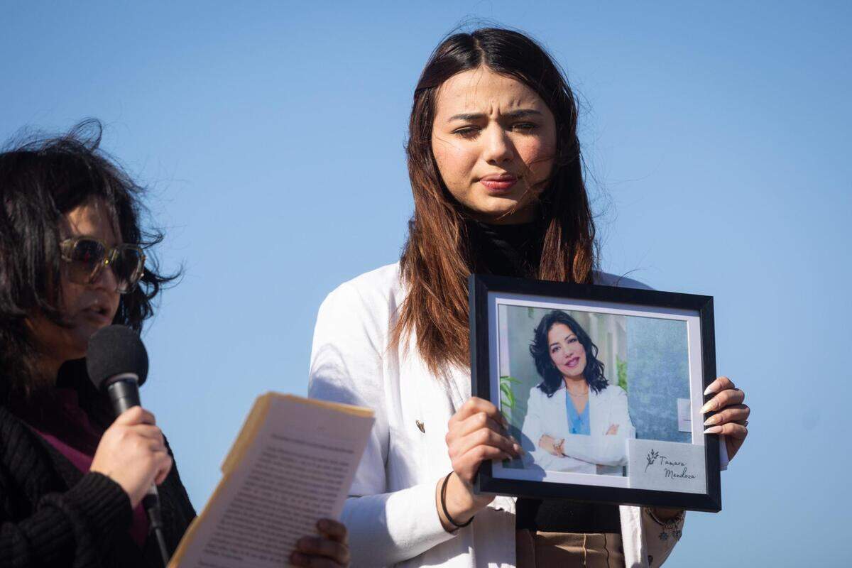 Marielena De Freites holds a photo of her mother, Tamara Mendoza, at a memorial a year after the deadly I-35W crash Friday, Feb. 11, 2022, at Riverside Park in Fort Worth.
