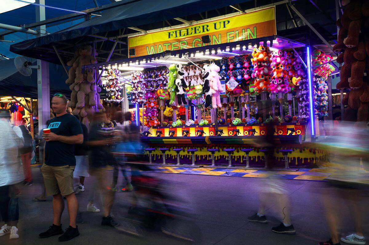 One of the many carnival games located on The Midway of the State Fair of Texas glows as the sun sets on opening day on Friday, September 24, 2021, in Dallas.