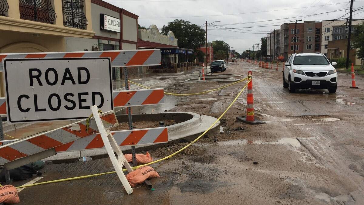 Drivers dodge potholes and puddles on Race Street.