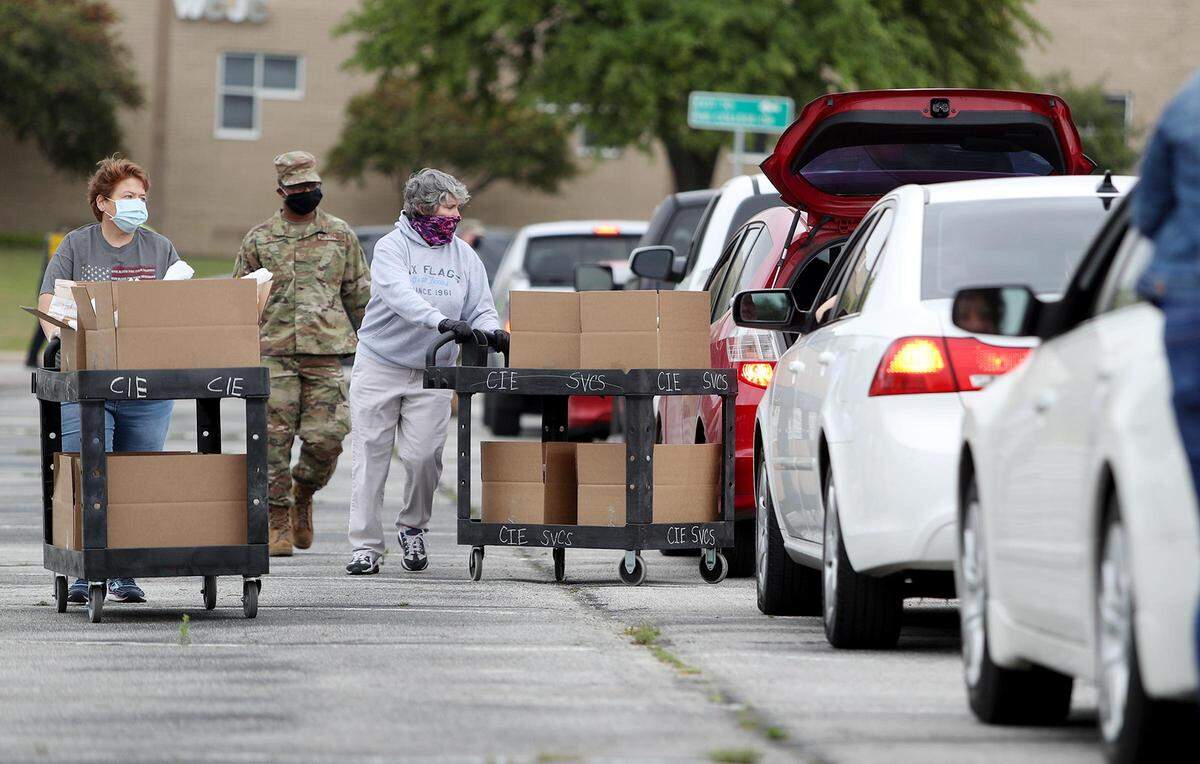 Volunteers with the Tarrant Area Food Bank and members of the Texas Air National Guard distribute food to those in need on Friday, April 17, 2020, at Tarrant Community College’s Northwest campus. The Tarrant Area Food Bank is experience about a 60 percent increase in distribution due to the newly laid off and furloughed due to the COVID-19 pandemic said Julie Butner, president and chief executive officer of the Tarrant Area Food Bank.