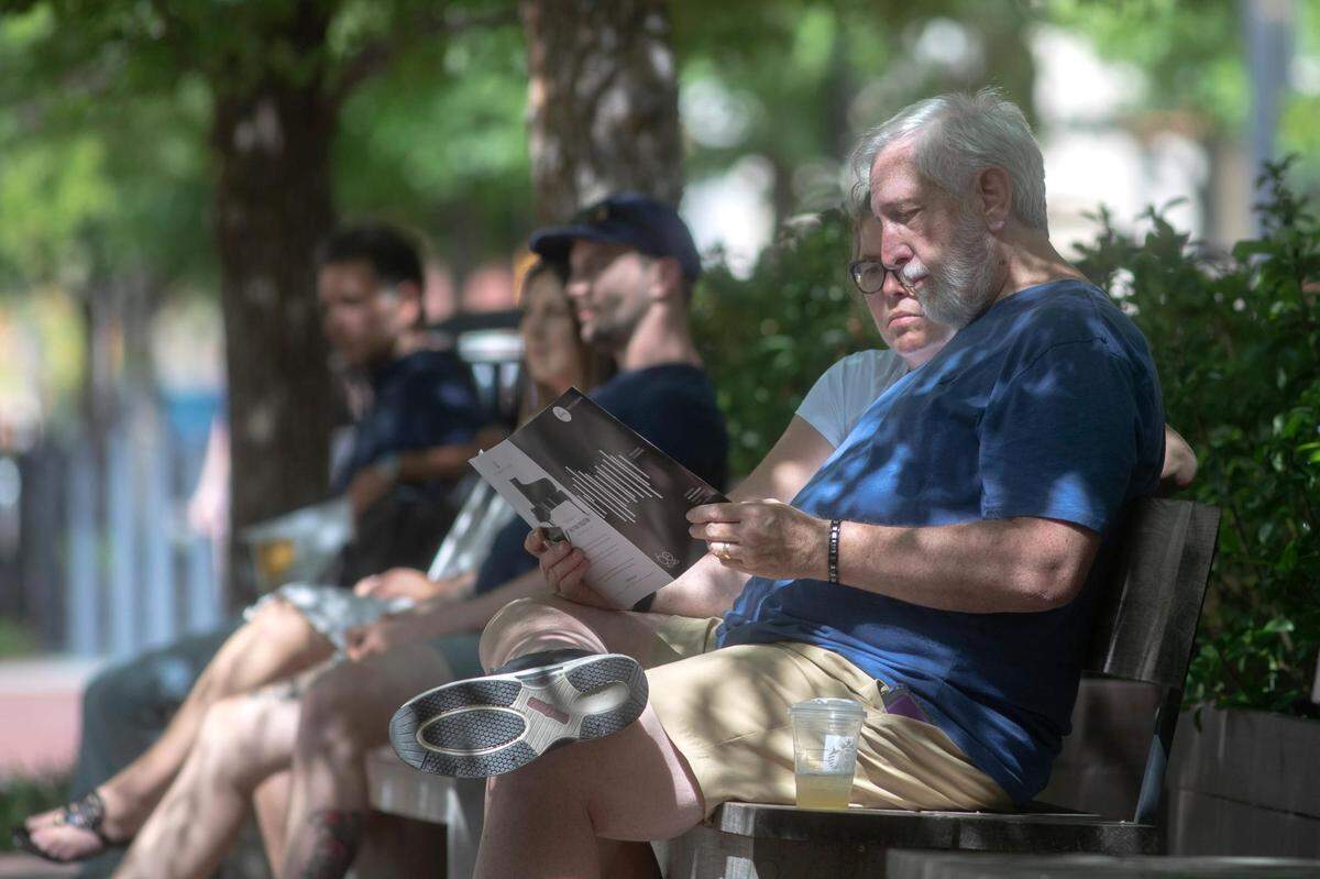 Jenny and Mike Keena, of Fort Worth, read the schedule for the 2022 Van Cliburn International Piano Competition finals, livestreamed in Sundance Square on Saturday, June 18, 2022, in Fort Worth, Texas.