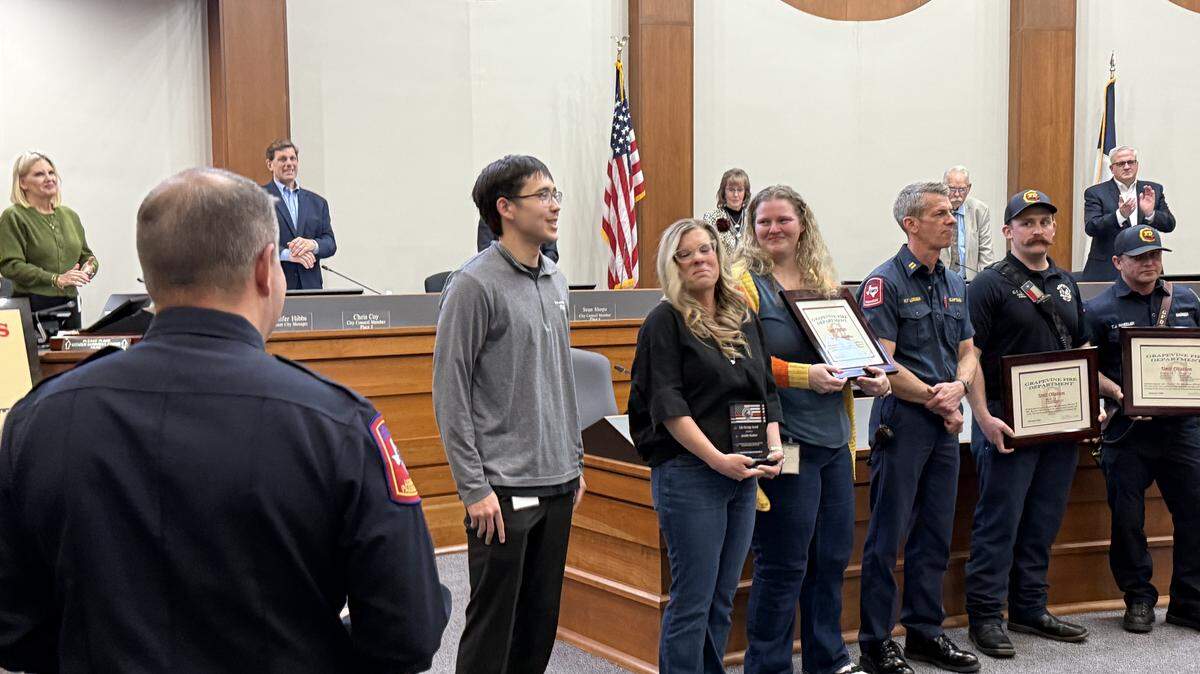 Members of the Grapevine Parks and Recreation team, the dispatch alarm team, and members of the fire department were recognized by Assistant Fire Chief, Wes Williams at the Feb 3 city council meeting for saving the life of Zach Smith (left gray sweater) who went into cardiac arrest at The REC in Grapevine on December 15.