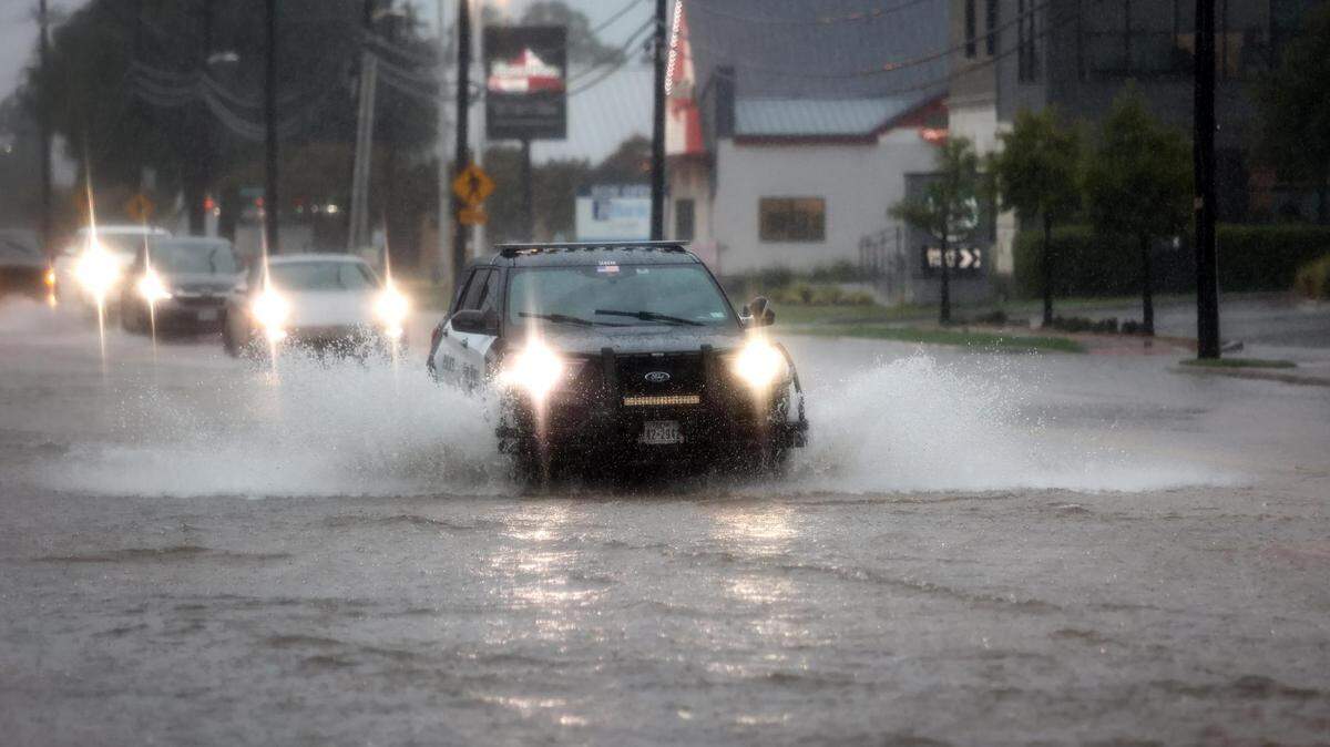A Fort Worth Police Department vehicle drives through a flooded section of University Drive on Monday, August 22, 2022.
