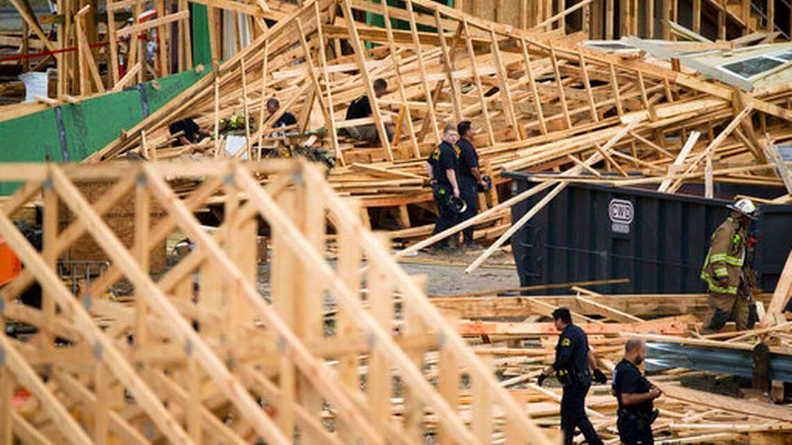 Emergency workers attempt to rescue people trapped under a three-story structure under construction that collapsed in Dallas, Monday, Oct. 8, 2018. A construction worker is dead and five co-workers are hospitalized with injuries after a three-story town house they were building west of downtown Dallas collapsed during a thunderstorm.