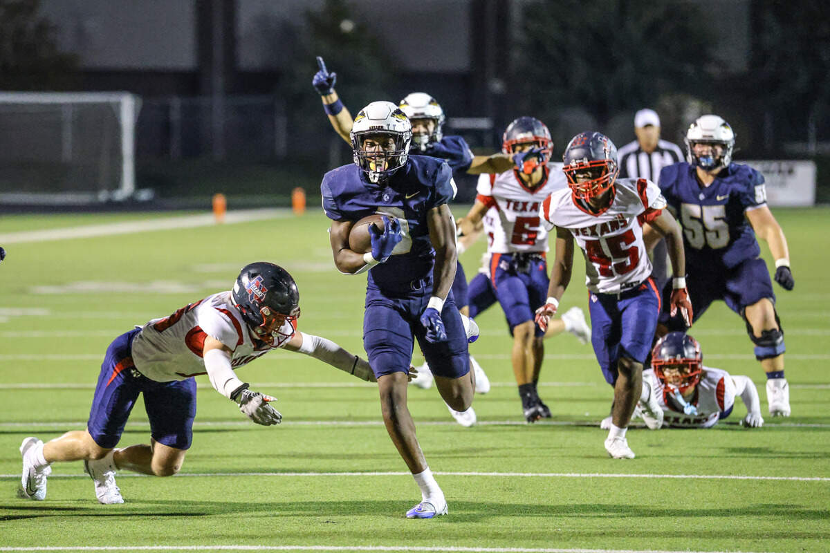 Keller running back Temi Ericson (0) breaks past the Justin Northwest defensive front on his way to a 25-yard touchdown in overtime to win a District 4-6A game Friday at Keller ISD Stadium.