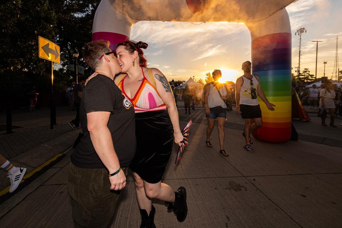 Partners Shellie Smalley and Megan Truesdell share a moment together under the cooling tent area at the Arlington Pride event at Levitt Pavilion in Arlington on Saturday, June 8, 2024.