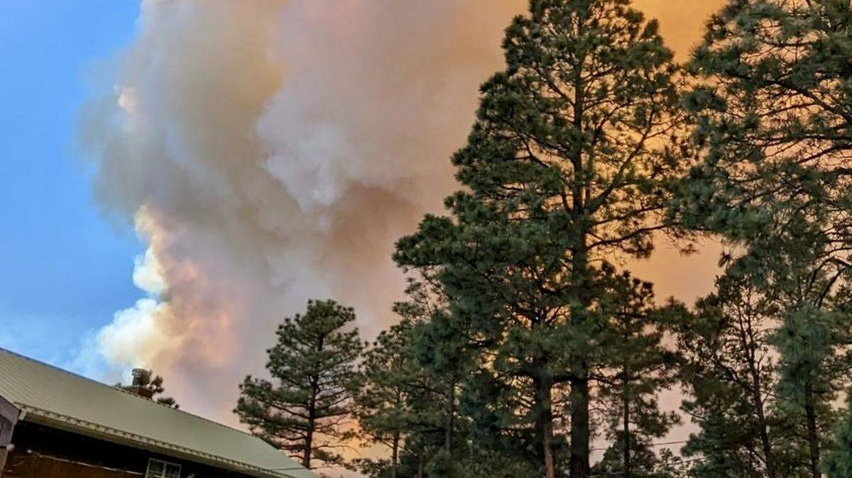 A fire plume rises and the sky is turning orange over Fort Worth musician Dave Millsap’s home in Alpine Cellars Village, New Mexico, during the Ruidoso fire June 17, 2024.