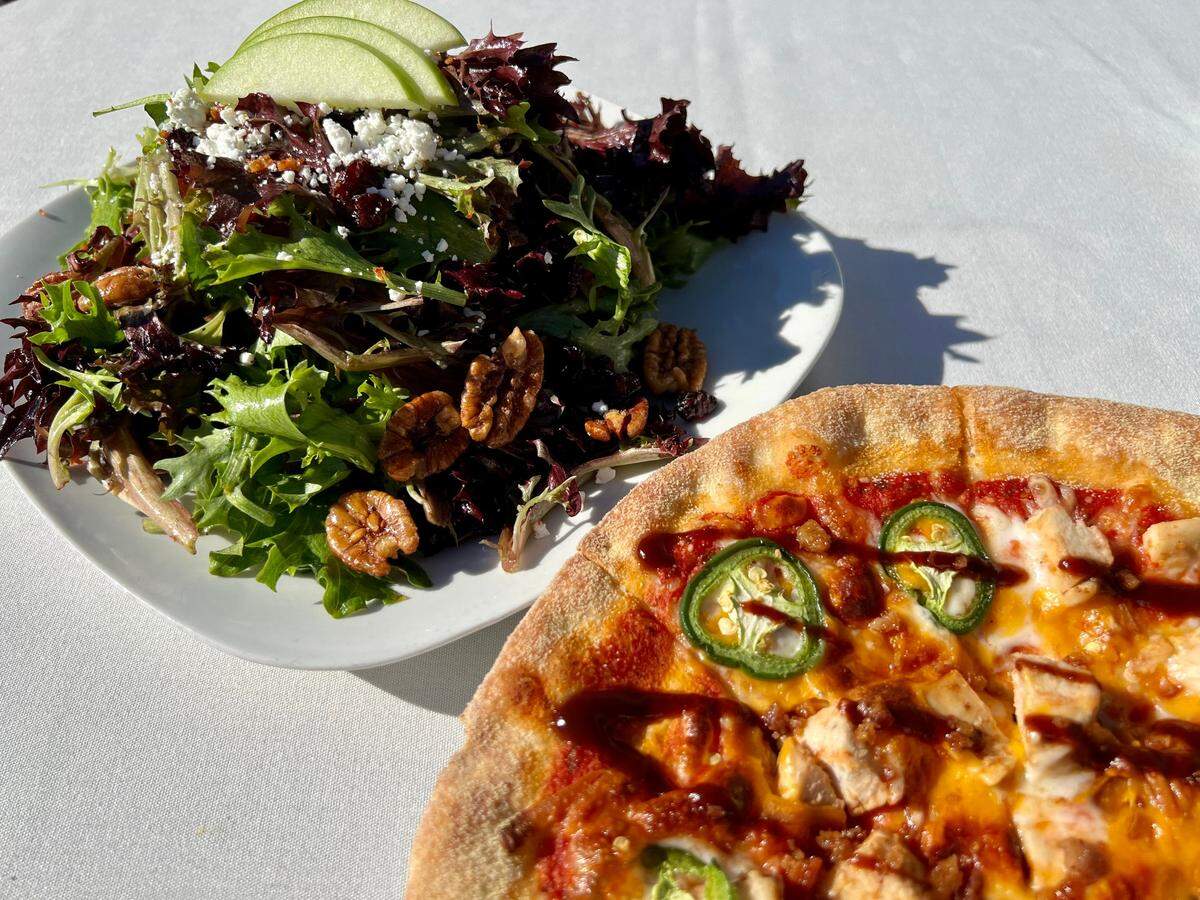 A Winslow pecan-apple salad and a “Jim Bowie” chicken-bacon-jalapeno pizza at Winslow’s Wine Cafe.