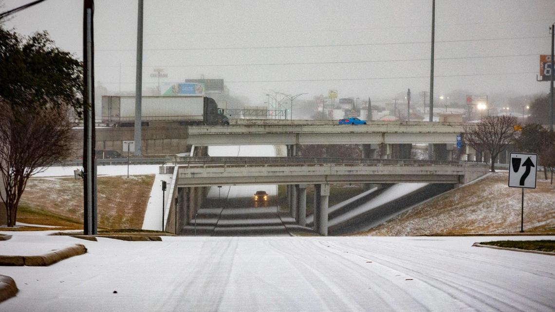 Cars drive over an I-30 underpass with icy weather in Fort Worth on Tuesday, Jan. 31, 2023. Winter storm conditions have extended through Thursday morning as freezing rain continues.