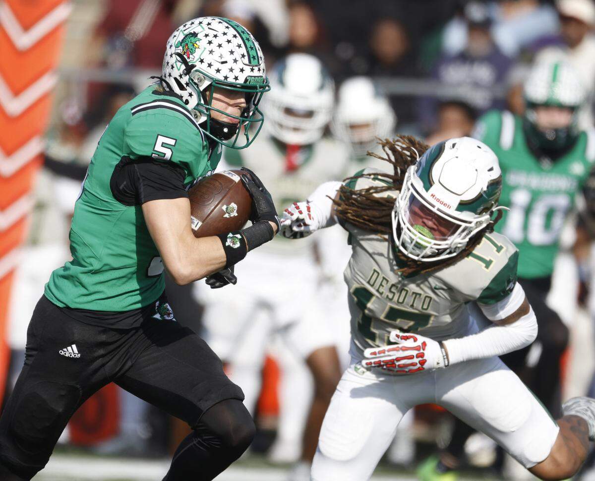 Southlake Carroll wide receiver Blake Gunter (5) cuts in front of DeSoto free safety Damarion Ross for the Dragons’ first score of the game during the first half of a Class 6A Division II state semifinal Saturday at Newsom Stadium in Mansfield.