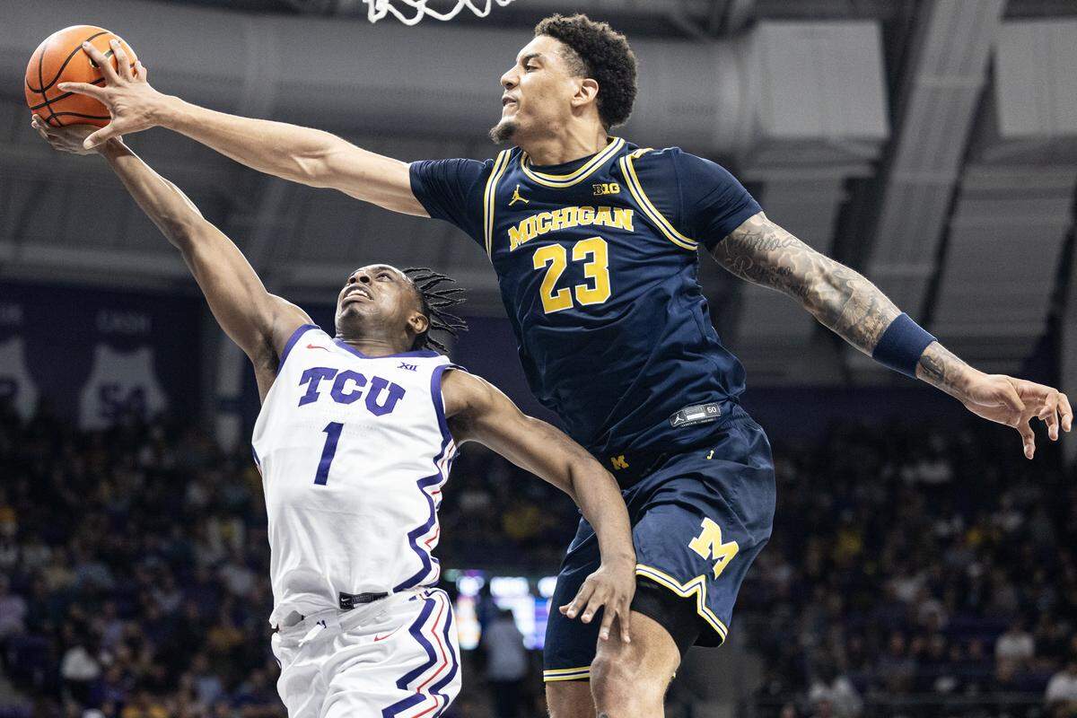 TCU guard Jayden Pierre (1) is blocked at the rim by Michigan forward Yaxel Lendeborg (23) in the first half of a NCAA basketball game between the TCU Horned Frogs and the Michigan Wolverines at Schollmaier Arena in Fort Worth on Friday, Nov.14, 2025.