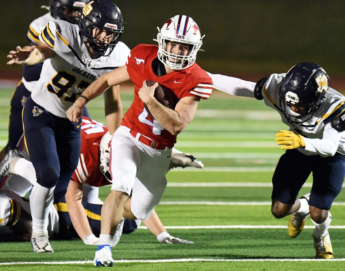 Grapevine’s Parker Polk, center, races past Arlington Heights’ Henry Mankin, left, and Keith Guidry for a first down in the first quarter of Friday’s October 28, 2022 District 4-5A Division 2 football game at Mustang-Panther Stadium in Grapevine, Texas. Special/Bob Haynes