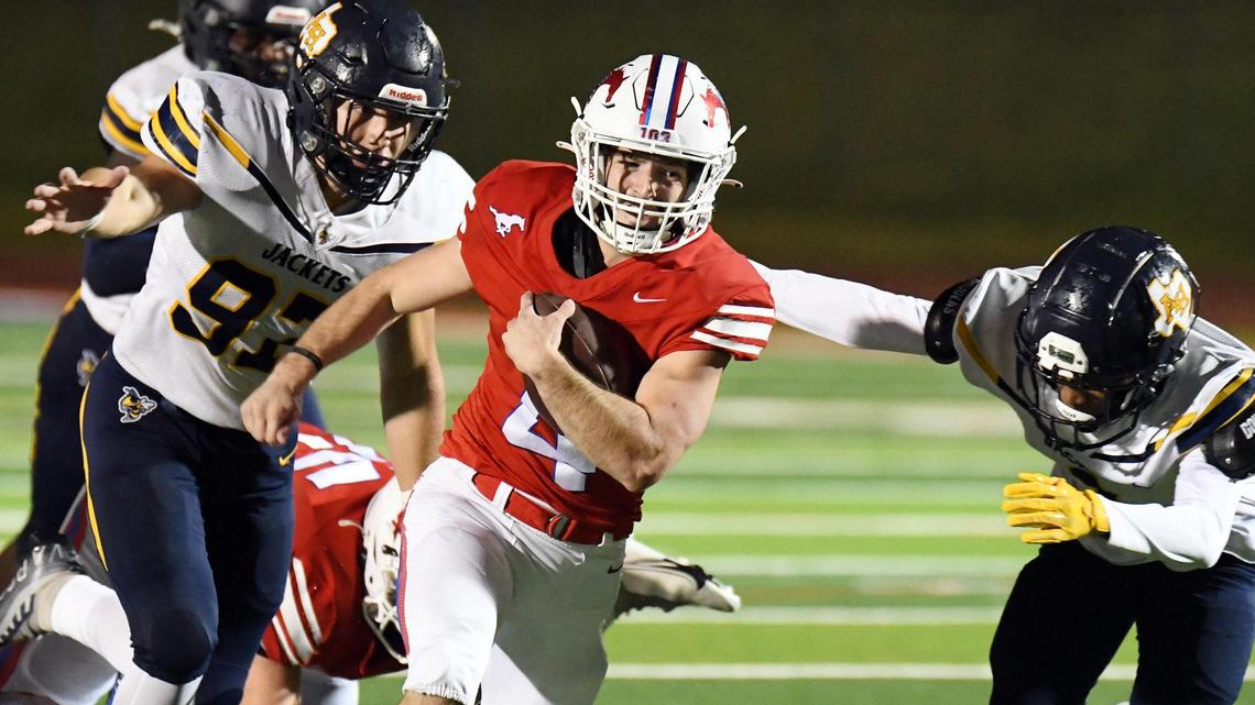 Grapevine’s Parker Polk, center, races past Arlington Heights’ Henry Mankin, left, and Keith Guidry for a first down in the first quarter of Friday’s October 28, 2022 District 4-5A Division 2 football game at Mustang Panther Stadium in Grapevine, Texas. Special/Bob Haynes