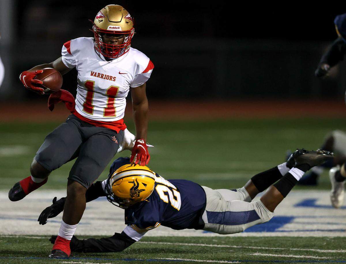 South Grand Prairie running back Ira Stuckey (11) tries to avoid Arlington Lamar defensive back Braylon Cole (26) for a nice run during the first half in a District 8-6A high school football game played at Cravens Field on Thursday, November 4, 2021, in Arlington. (Steve Nurenberg/Special to the Star-Telegram)