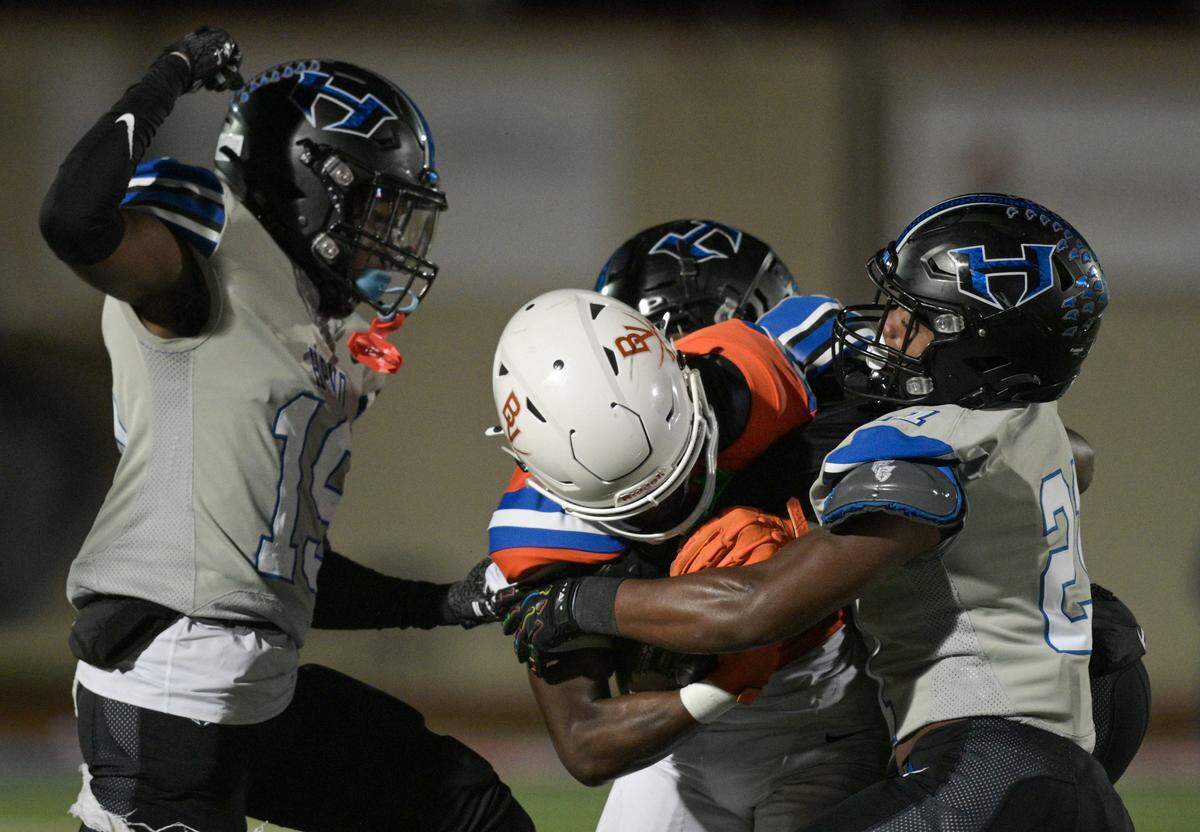 Bowie Volunteer wide receiver Keidric Osunde-brown (4) gets swarmed by Hebron defensive players during a UIL football playoff game against Hebron High School at Mustang-Panther Stadium in Grapevine, Texas on Friday, Nov. 22, 2024.